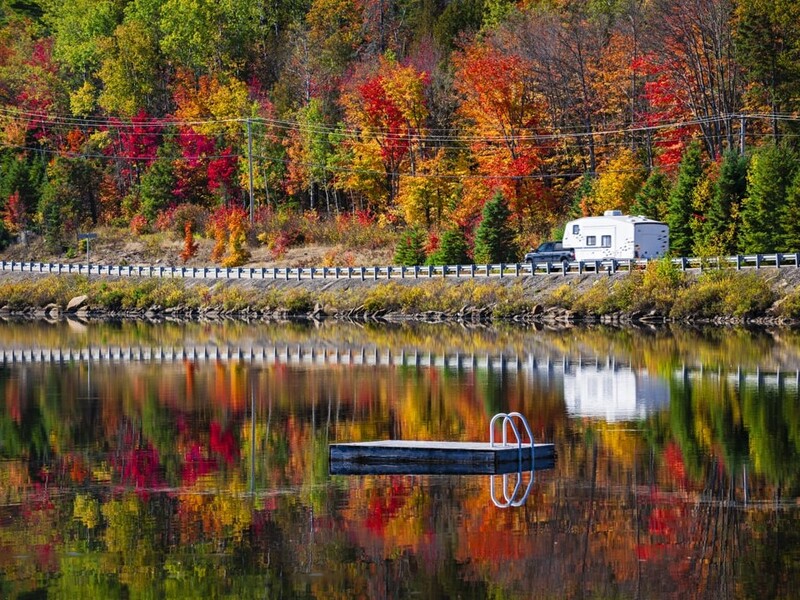 Camper rijdt door herfstbos in Canada