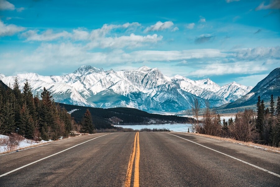 snelweg met sneeuw bedekte rotsachtige bergen in de winter op Kootenay vlaktes gebied, Alberta, Canada