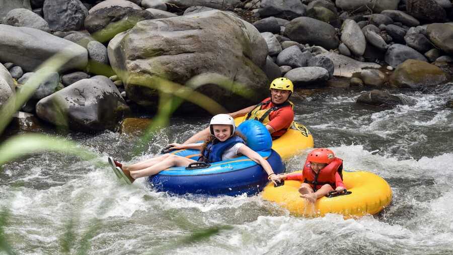 Tuben met het gezin over een rivier van Costa Rica