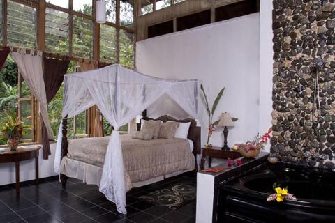 Suite met kingsize bed en bubbelbad in Forres Park Nature Retreat