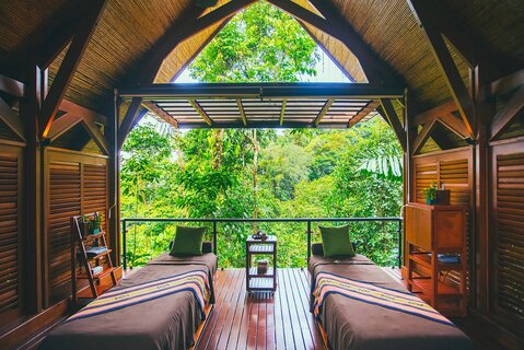 Vrouw doet yoga in casita in het Amor Arenal hotel