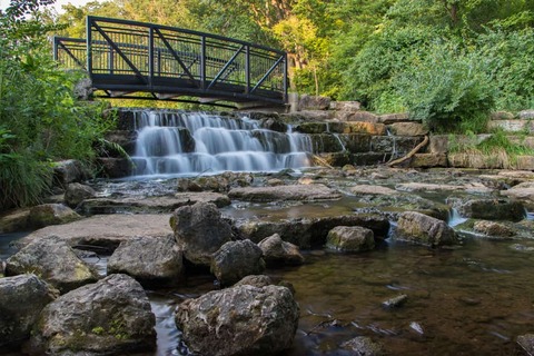 voetgangersbrug over een kleine waterval in een openbaar park in Springfield, Missouri.
