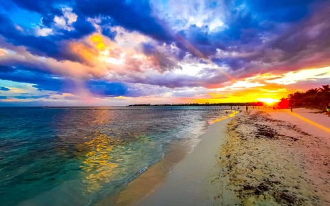 zonsopgang in het tropische Mexicaanse Caribische strandlandschap, met helder turkooisblauw water, resorts en palmbomen in Playa del Carmen, Mexico.