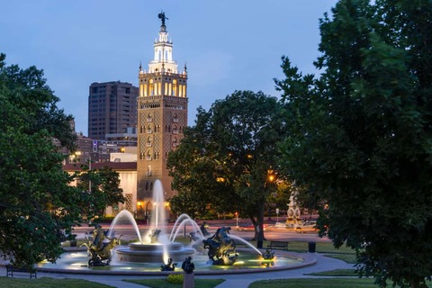 Een zonsondergang met uitzicht op een historische fontein en de skyline van Kansas City, Missouri, VS.
