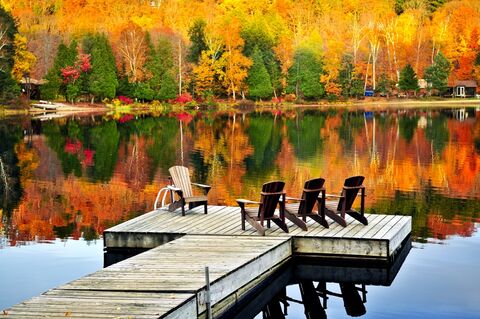 Houten dok met stoelen op herfstmeer