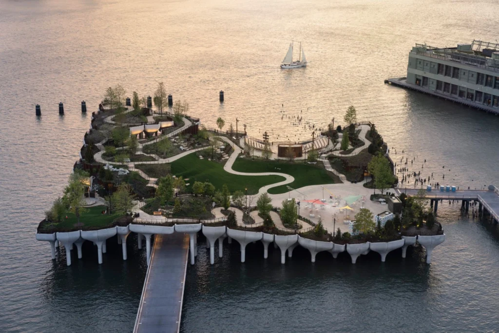 Luchtfoto van het kunstmatige eilandpark Little Island met kronkelende paden en groen uitstekend in het water bij New York
