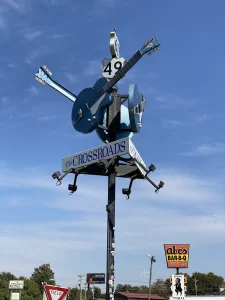 Sculptuur van gekruiste blauwe gitaren op een paal met het opschrift The Crossroads bij de kruising van Highway 61 en 49