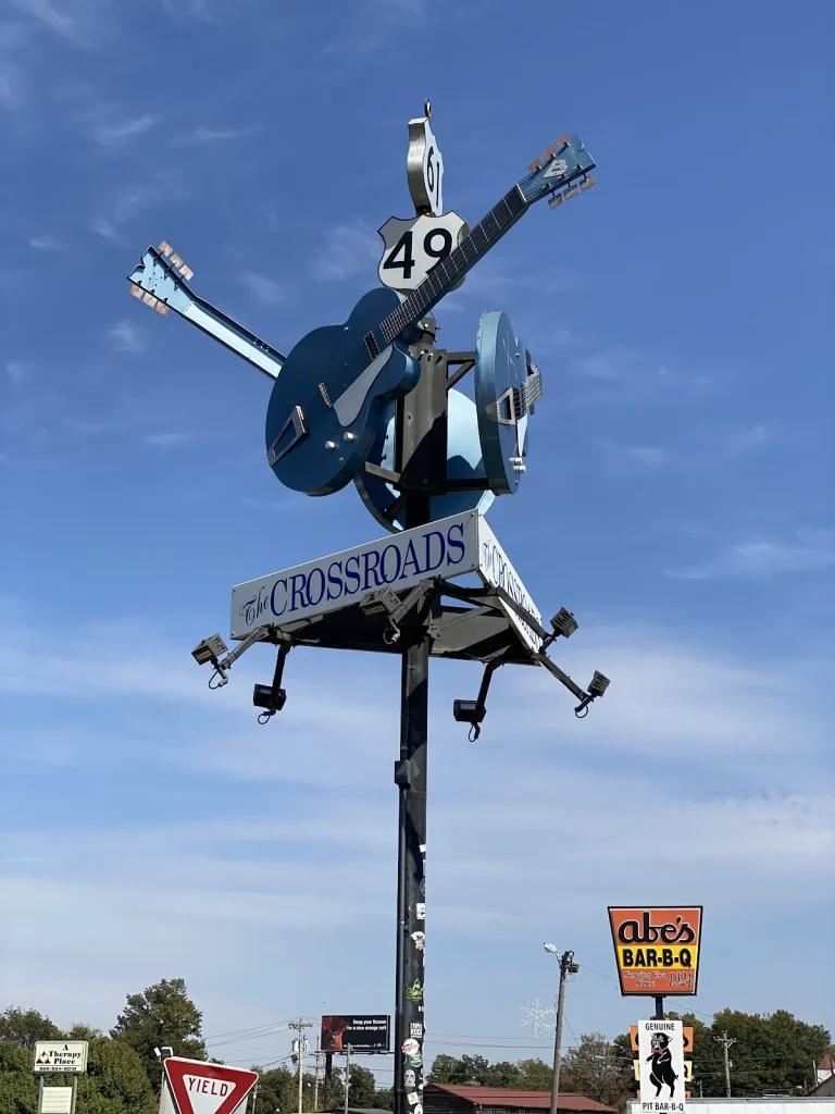 Sculptuur van gekruiste blauwe gitaren op een paal met het opschrift The Crossroads bij de kruising van Highway 61 en 49