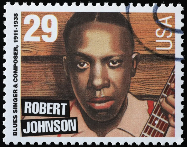 Postzegel met een geschilderd portret van bluesmuzikant Robert Johnson met gitaar en de tekst blues singer and composer