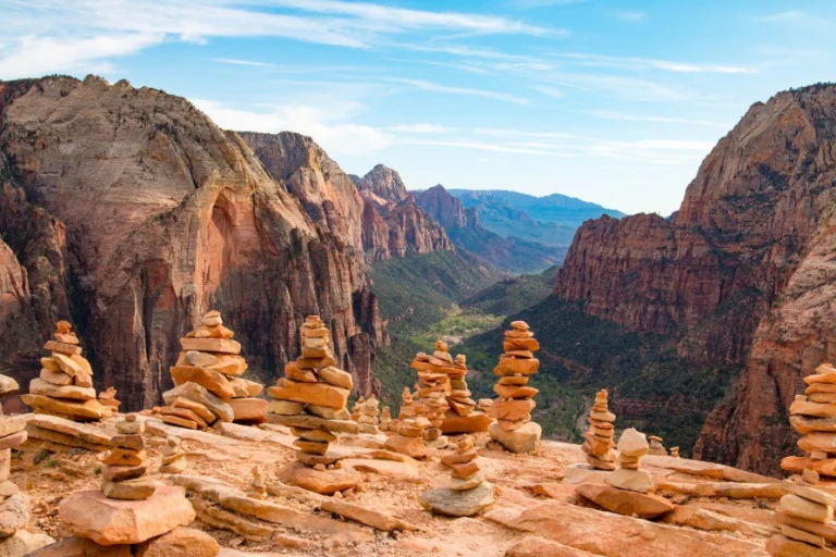 Stenen stapeltjes op een rotsrichel met uitzicht over de diepe canyons en rode rotswanden van Zion National Park in Utah