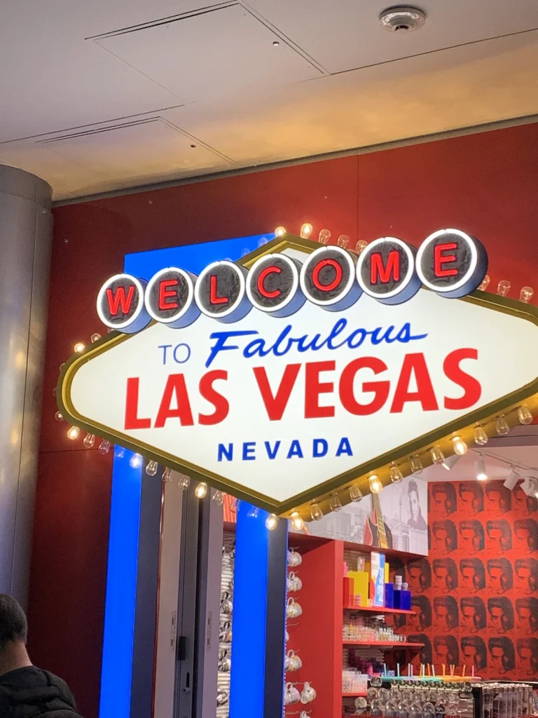 Verlicht bord met de tekst Welcome to Fabulous Las Vegas Nevada hangt binnen in een souvenirwinkel