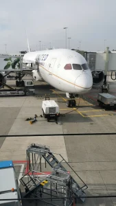 Neus van een wit vliegtuig van United Airlines staat aangesloten aan de slurf bij een gate op het platform
