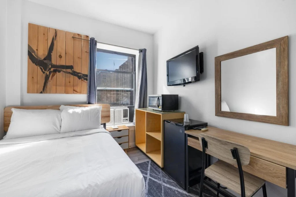 Compact en eenvoudig ingerichte budgethotelkamer met tweepersoonsbed in Hotel 27, een betaalbaar hotel in Manhattan