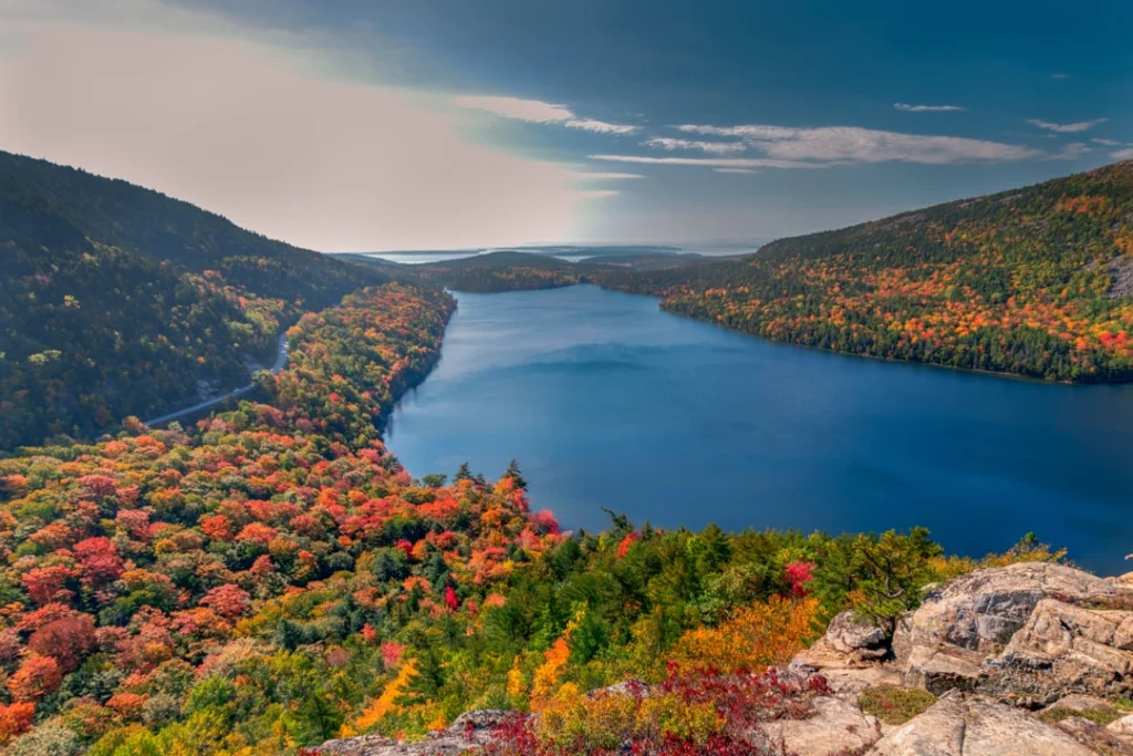 Luchtfoto van het blauwe water van Jordan Pond omringd door bossen in felle herfstkleuren in Acadia National Park in Maine
