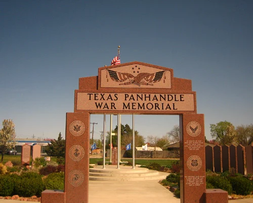 Stenen poort met de tekst Texas Panhandle War Memorial en een Amerikaanse vlag boven de doorgang, met gedenkstenen aan weerszijden