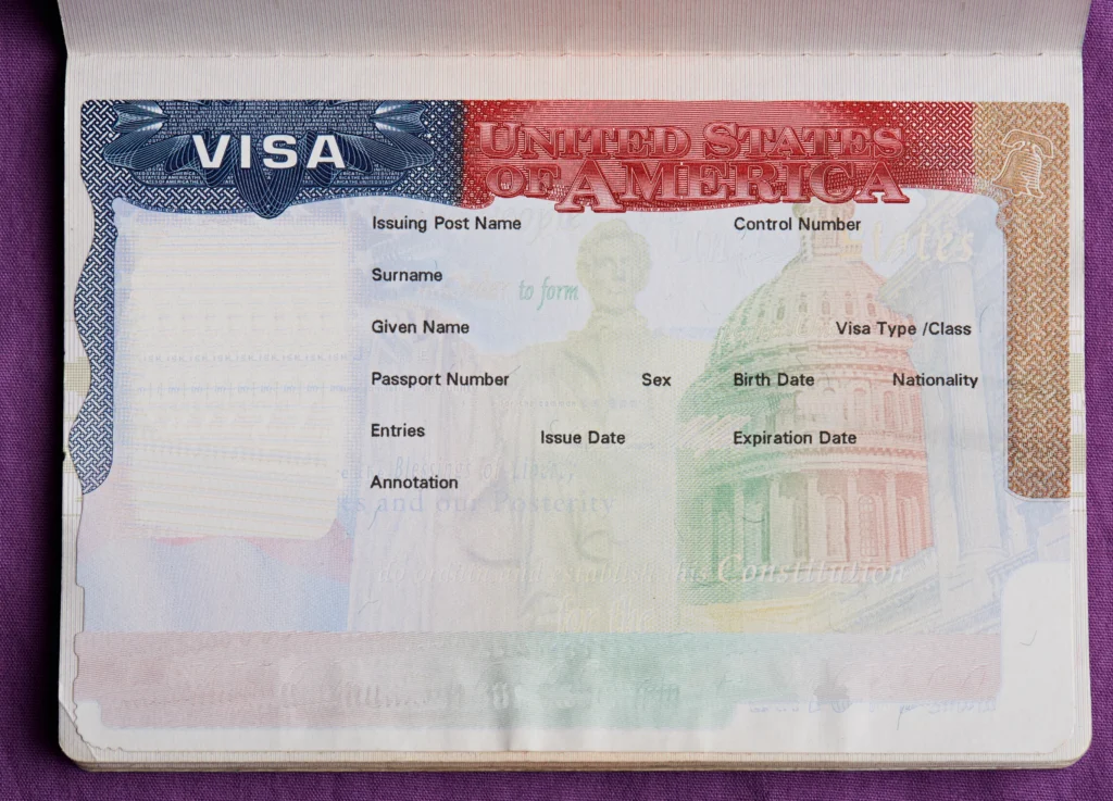 Close-up van een leeg Amerikaans visumdocument met invulvelden zoals naam, paspoortnummer en geldigheidsdatum, geplakt in een paspoort