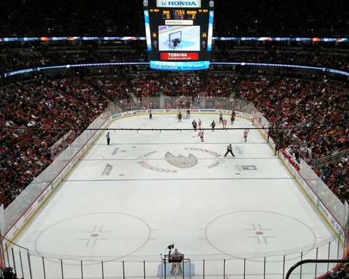 IJshockeyspelers op de ijsbaan van het volle Honda Center tijdens een wedstrijd, gezien vanaf de hoge tribune
