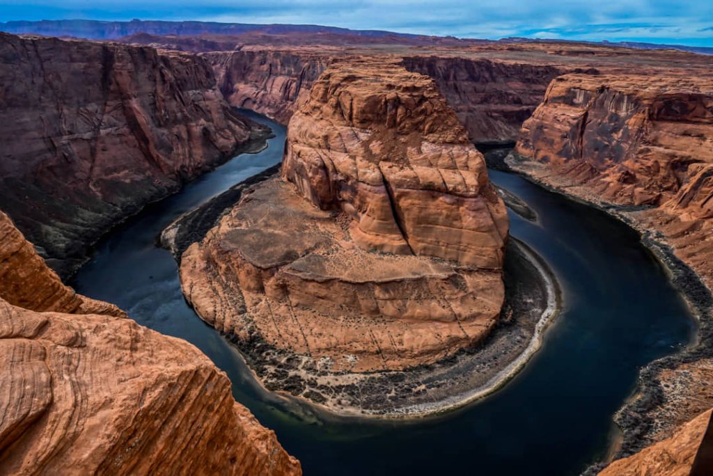 Uitzicht vanaf de rand van een rotswand op de hoefijzervormige bocht van de Colorado rivier tussen rode rotsen in Arizona