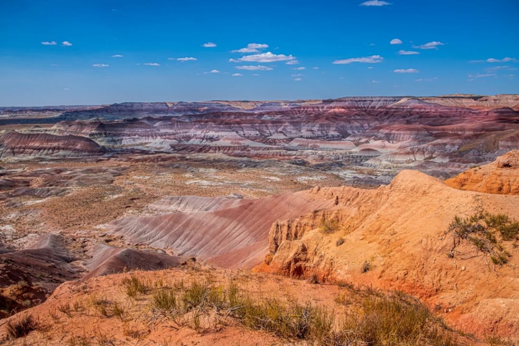 Uitgestrekt woestijnlandschap met roze, paarse en oranje gestreepte heuvels in de Painted Desert in Arizona