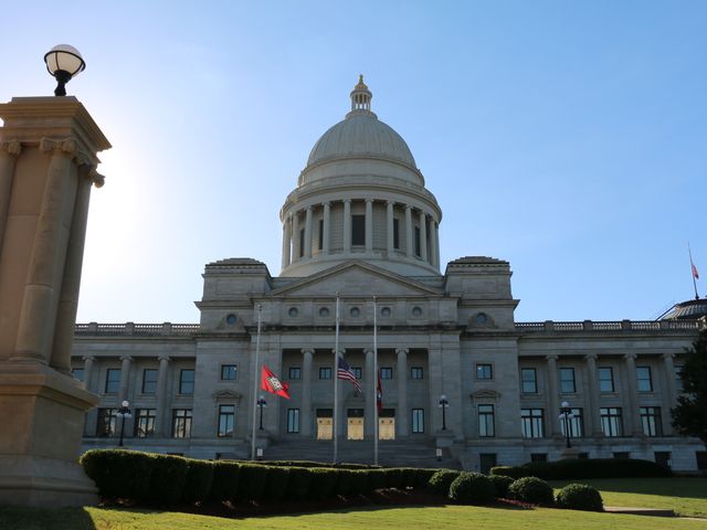 Het imposante State Capitol van Arkansas met witte koepel, zuilen en Amerikaanse vlaggen voor het gebouw