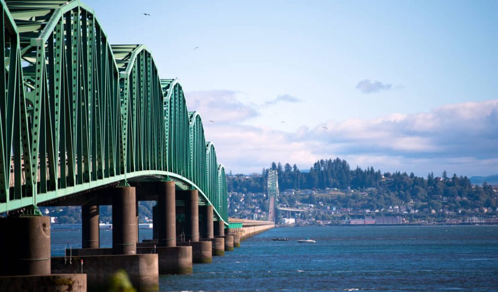 Close-up van de groene stalen constructie van de Astoria Megler brug die over het brede water van de Columbia rivier loopt