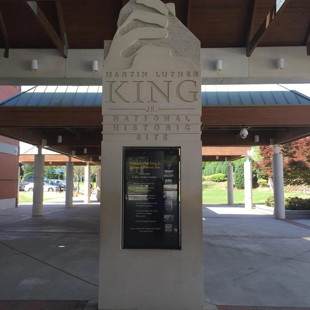 Stenen zuil met de tekst Martin Luther King Jr. National Historic Site en een informatiebord onder een overkapping in Atlanta