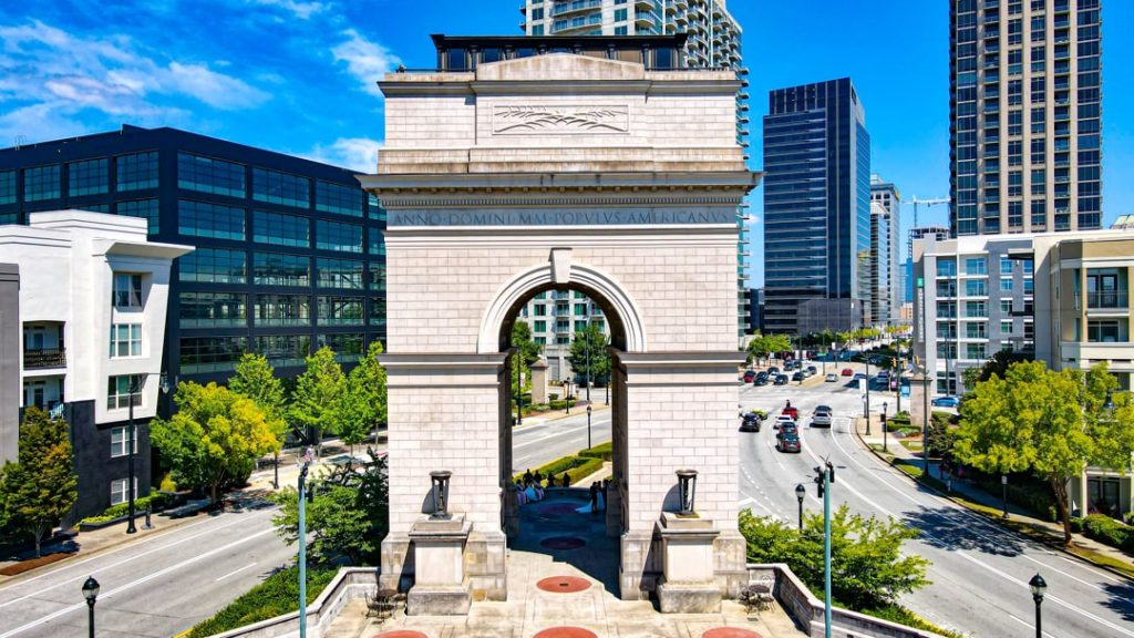 Luchtopname van de stenen triomfboog van de Millennium Gate op Atlantic Station in Atlanta, omringd door wolkenkrabbers en een drukke weg