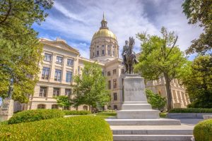 Gouden koepel van het Georgia State Capitol in Atlanta gezien tussen bomen door, met een ruiterstandbeeld op de voorgrond