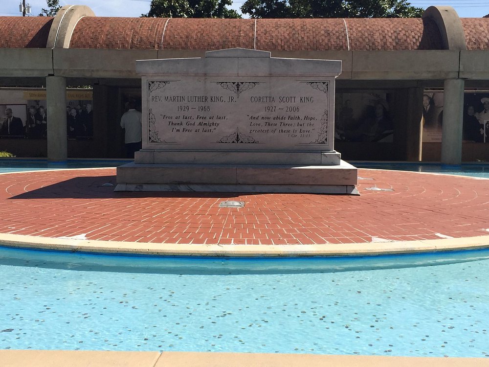 Witte marmeren tombe met inscripties voor Martin Luther King en Coretta Scott King, omgeven door een rechthoekige waterpartij