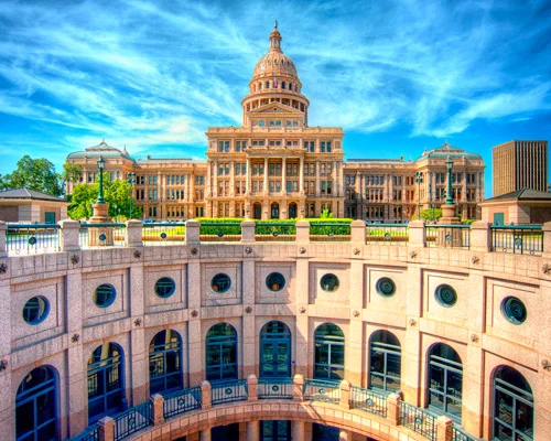 Onderaanzicht van de roze granieten arcade van het Texas Capitol in Austin, met de koepel torenhoog boven de boogramen