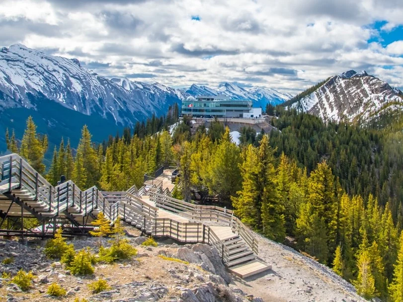 Het bovenstation en uitkijkplatform van de Banff Gondola op Sulphur Mountain, omringd door besneeuwde bergen