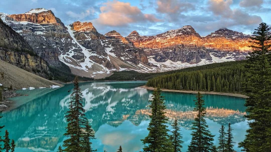 Turkooisblauw water van Moraine Lake weerspiegelt de besneeuwde bergtoppen van de Ten Peaks in Banff National Park