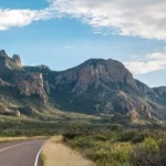 Lege tweebaansweg voert door een dal omringd door de kartelige pieken van de Chisos Mountains in Big Bend National Park
