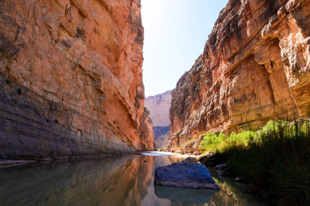 Kalme rivier stroomt tussen de steile, oranje rotswanden van Santa Elena Canyon in Big Bend National Park