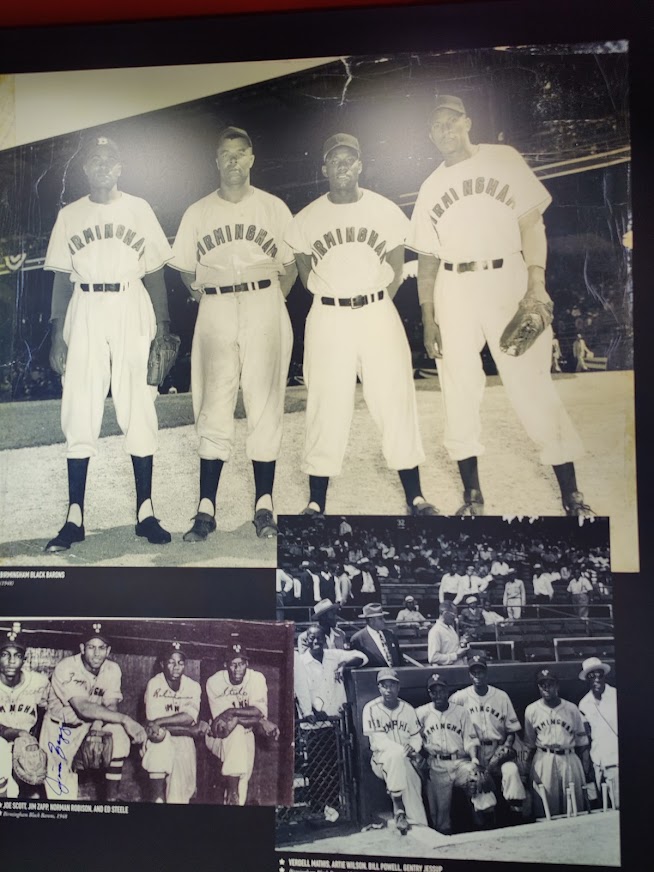 Zwart wit foto's van honkbalspelers van de Birmingham Black Barons in uniform, tentoongesteld op een informatiebord in Birmingham in Alabama