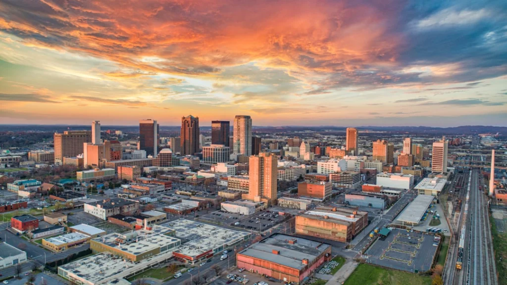 Luchtfoto van de wolkenkrabbers en gebouwen van downtown Birmingham in Alabama onder een kleurrijke avondlucht