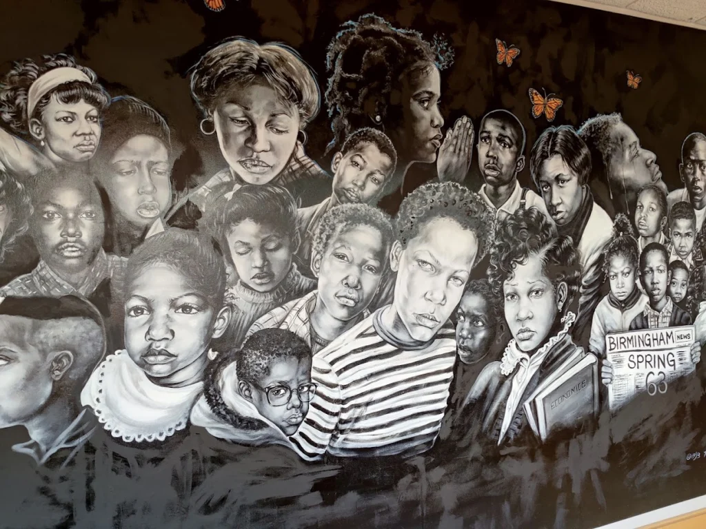 Zwart-witte muurschildering in Birmingham met gezichten van tientallen kinderen en jongeren, verwijzend naar de gebeurtenissen van Birmingham Spring 63