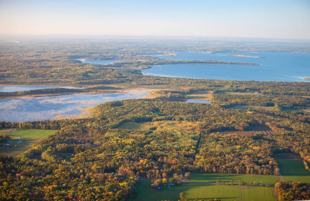Luchtfoto van meren en bos in herfstkleuren rond Brainerd Lakes in Minnesota, met akkers op de voorgrond