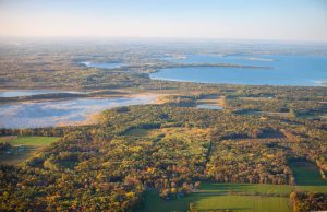 Luchtfoto van meren en bos in herfstkleuren rond Brainerd Lakes in Minnesota, met akkers op de voorgrond