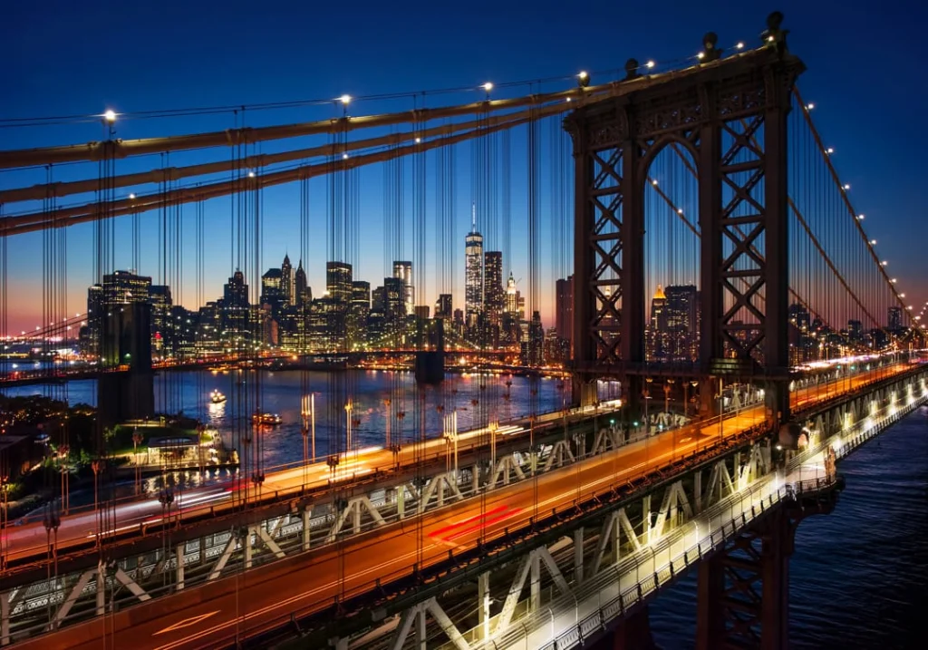 Manhattan Bridge bij nacht met lichtsporen van het verkeer en op de achtergrond de verlichte wolkenkrabbers van Lower Manhattan