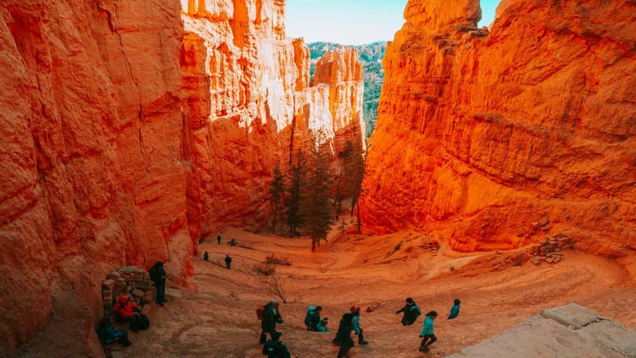 Groep wandelaars beneden tussen hoge oranje hoodoos en rotswanden in Bryce Canyon National Park