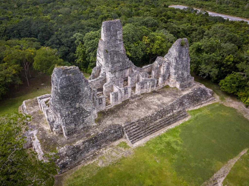 Luchtfoto van drie verweerde stenen tempeltorens omringd door dicht groen regenwoud bij Calakmul