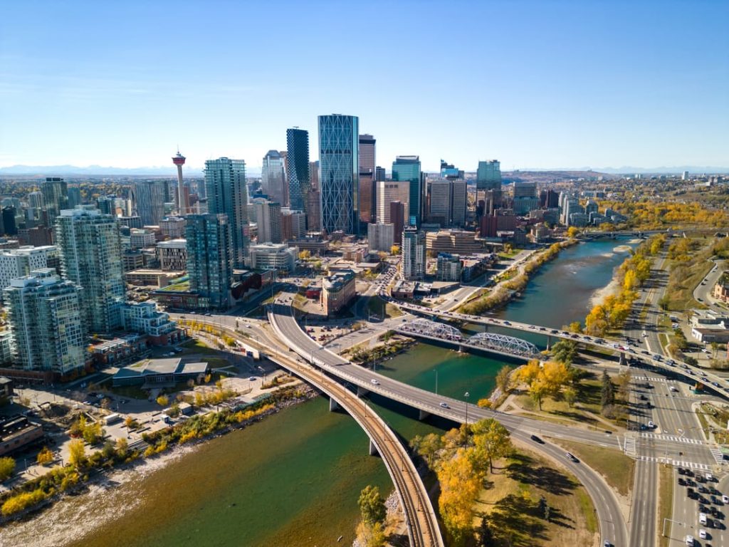Luchtfoto van het centrum van Calgary met bruggen over de rivier en herfstbomen langs de oevers