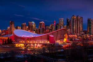 De skyline van Calgary met de Saddledome en verlichte wolkenkrabbers tijdens de schemering