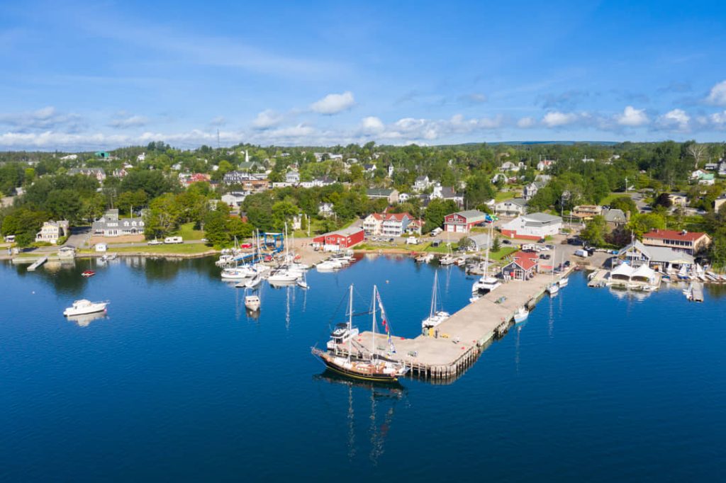 Luchtfoto van een havenstadje met huizen, een aanlegsteiger en boten aan het water op Cape Breton