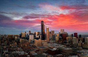 Panoramische luchtfoto van de skyline van Chicago in de avondschemering met een roze en paarse lucht boven de Willis Tower en de omliggende wolkenkrabbers