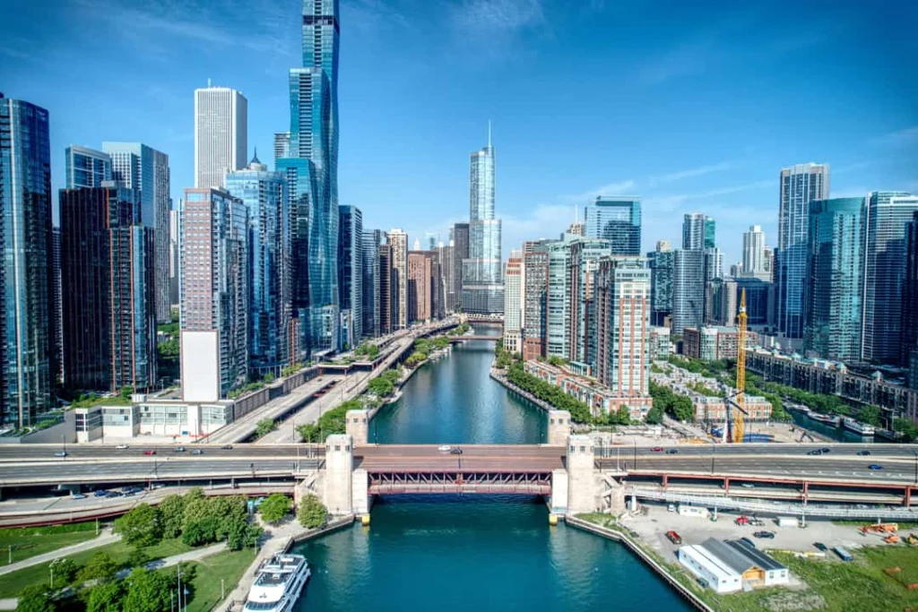 Luchtfoto van de Chicago River die tussen wolkenkrabbers door slingert met een ophaalbrug en boten op het water