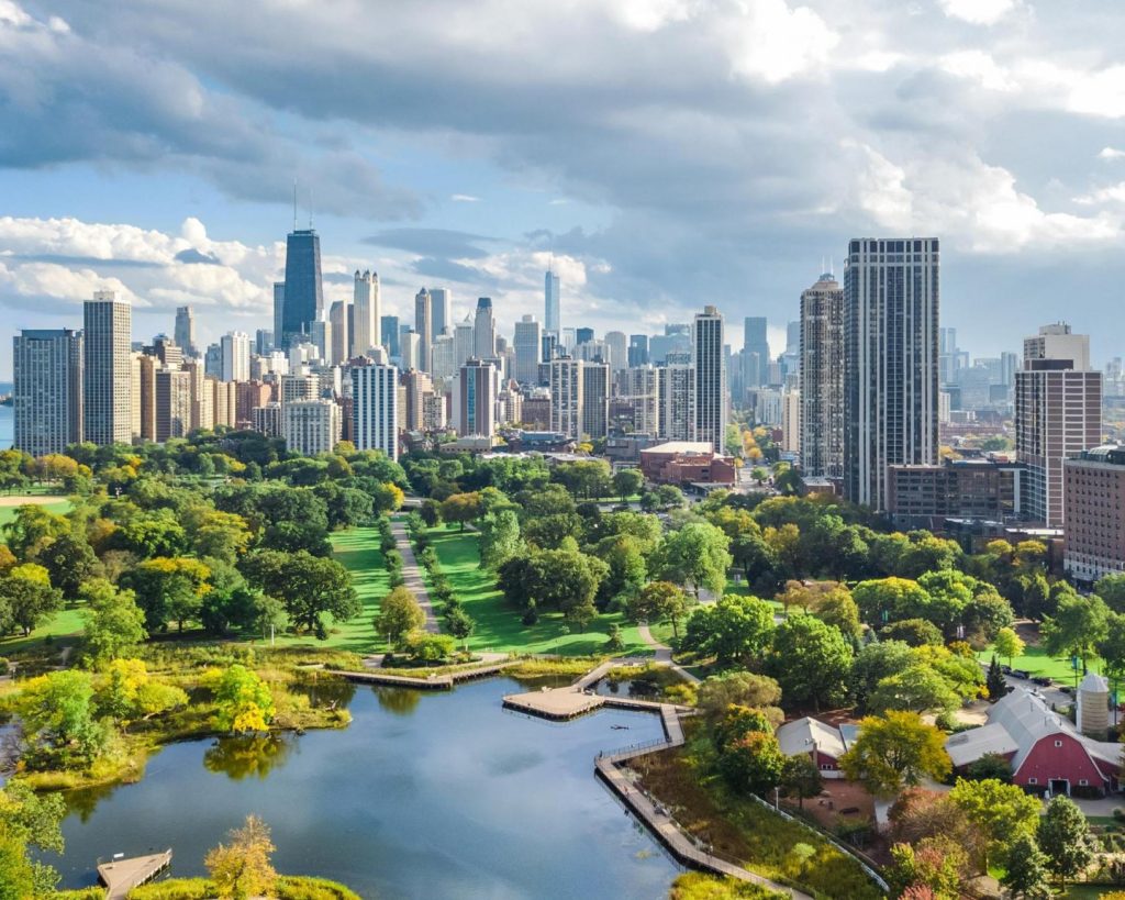 Groen park met een vijver en wandelpaden op de voorgrond en de wolkenkrabbers van Chicago aan het meer op de achtergrond