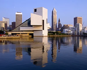 Glazen piramidevormig gebouw van het Rock and Roll Hall of Fame met de skyline van Cleveland weerspiegeld in het water
