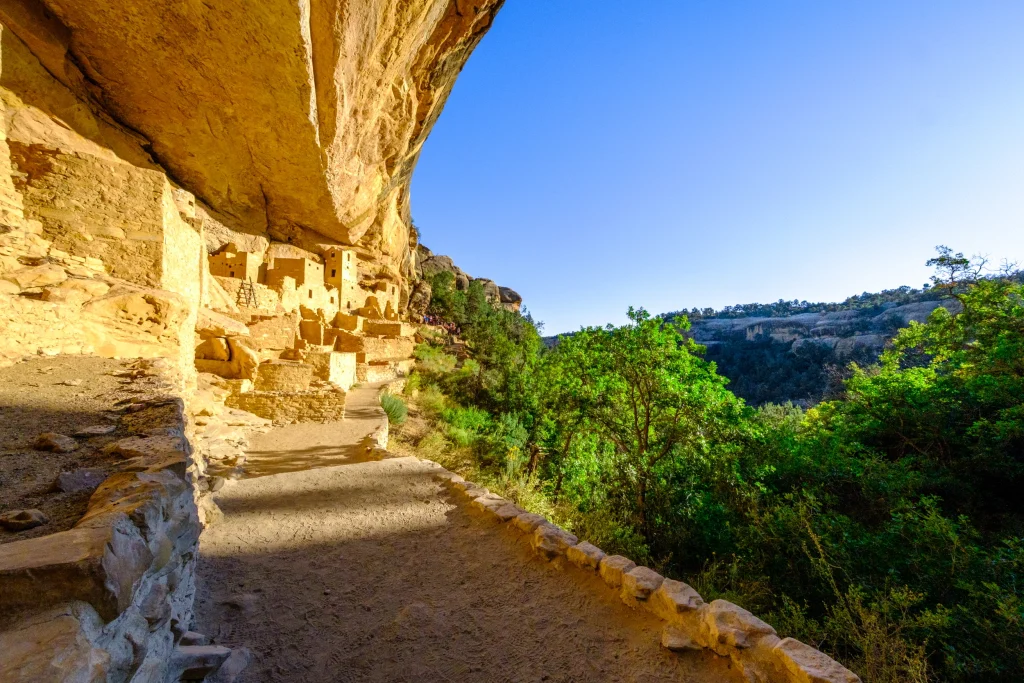 Wandelpad onder een overhangende rotswand langs oude klifwoningen van steen in Mesa Verde National Park in Colorado